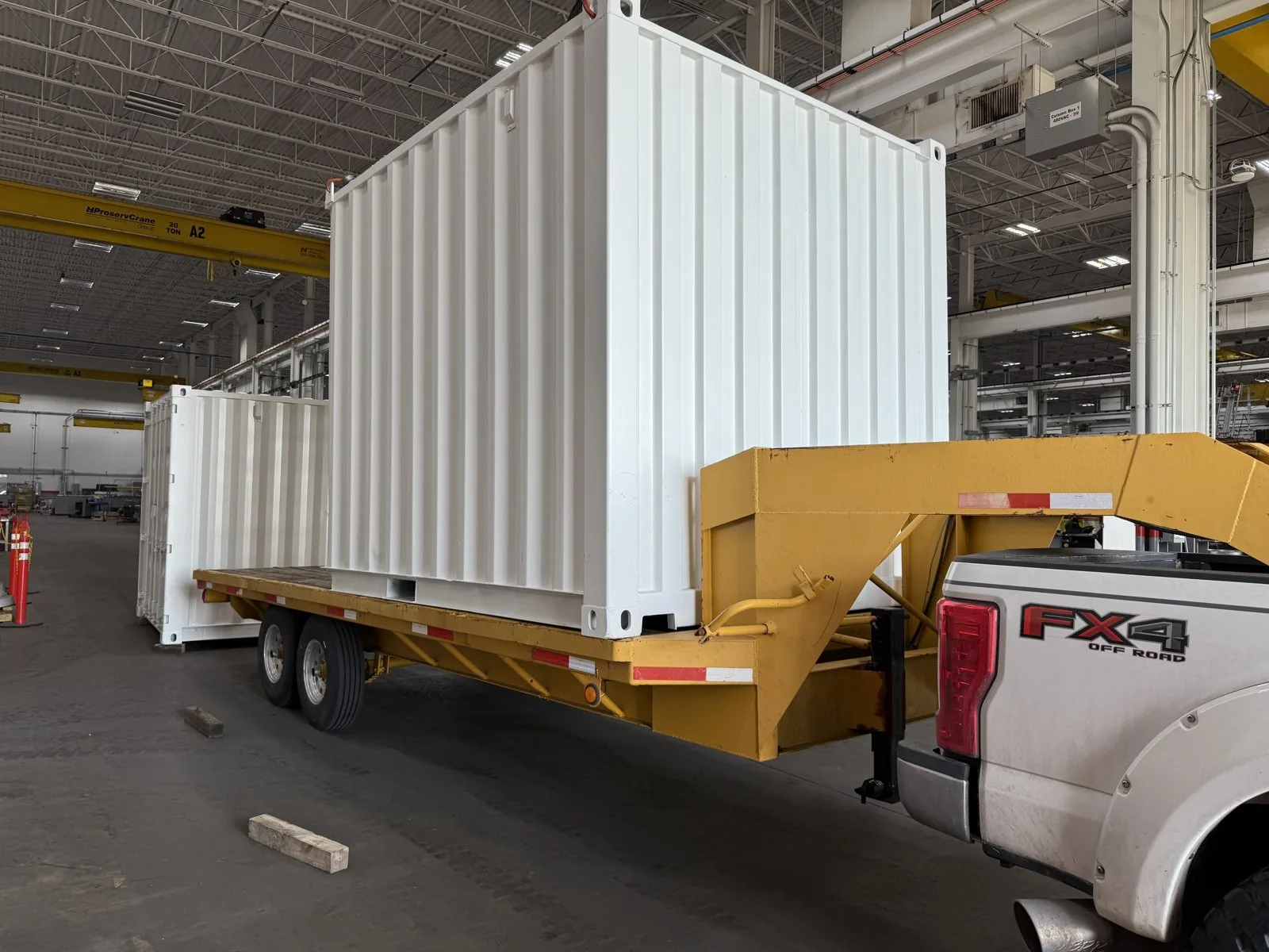 Modified shipping container loaded on a gooseneck trailer
